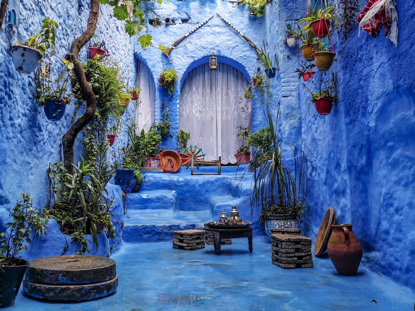 Chefchaouen — a blue alley with potted plants and a bench